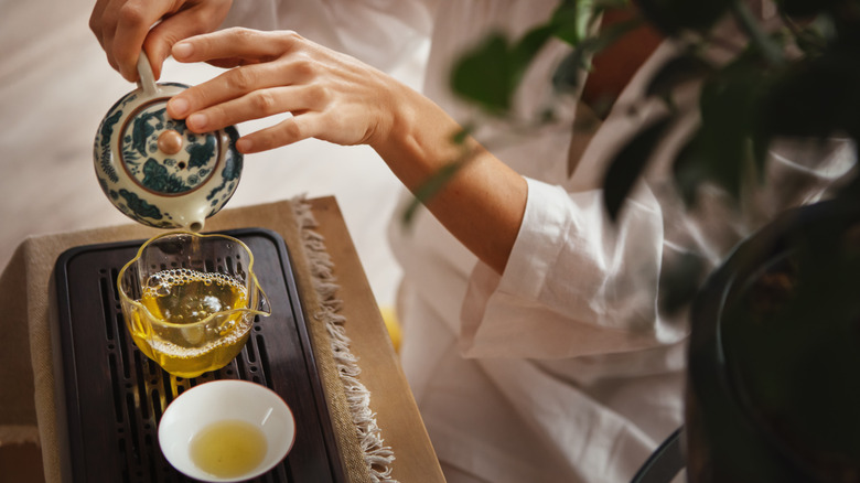 Person pouring a cup of green tea
