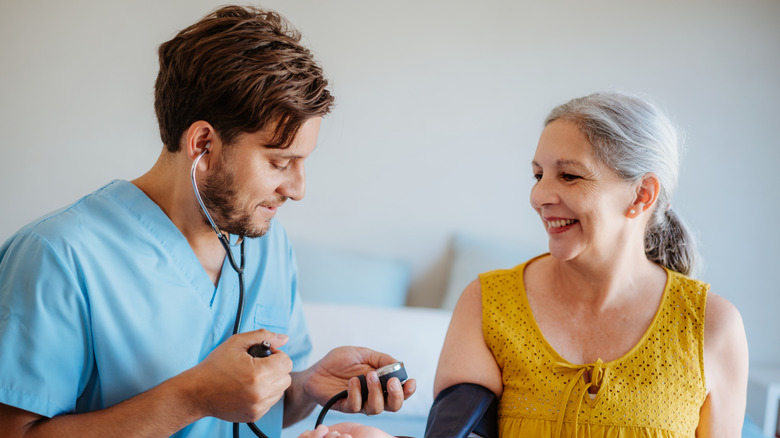 Healthcare professional measuring the blood pressure of a middle-aged woman