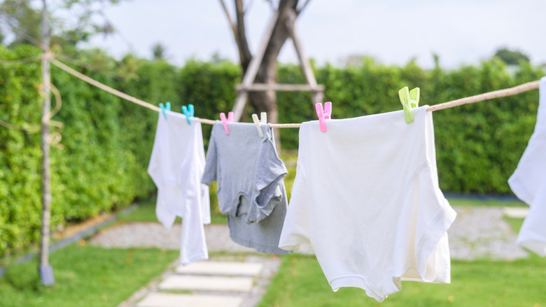 Clothes hang from a line in a yard