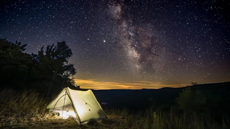 Tent at Cherry Springs State Park lit from the inside and the Milky Way in the night sky in the background