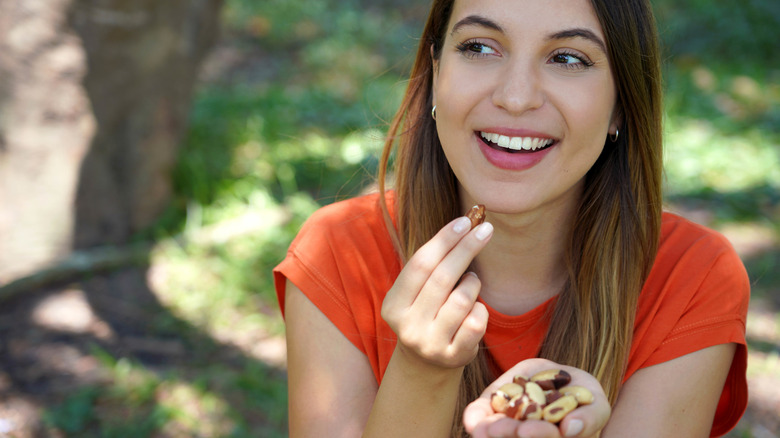 A woman eating a handful of nuts