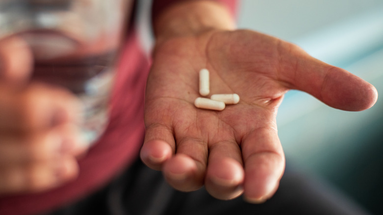 Close up photo of senior man's hand holding vitamin supplements