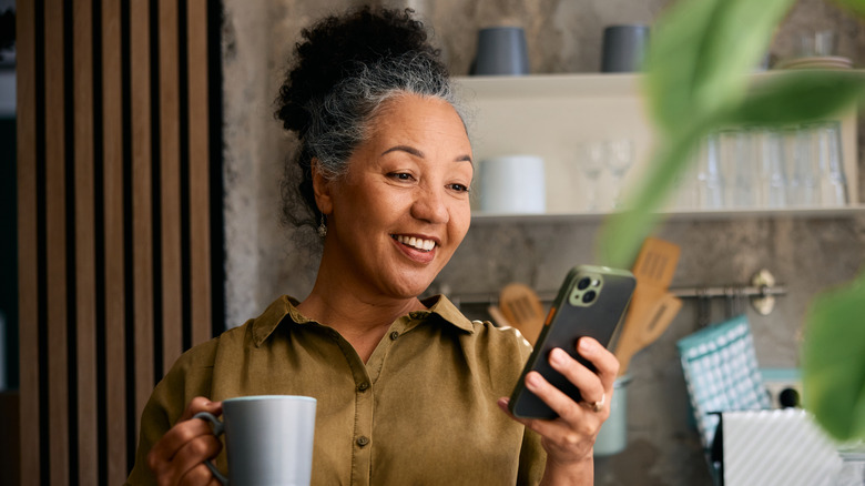 Middle-aged woman looking at her smartphone and smiling