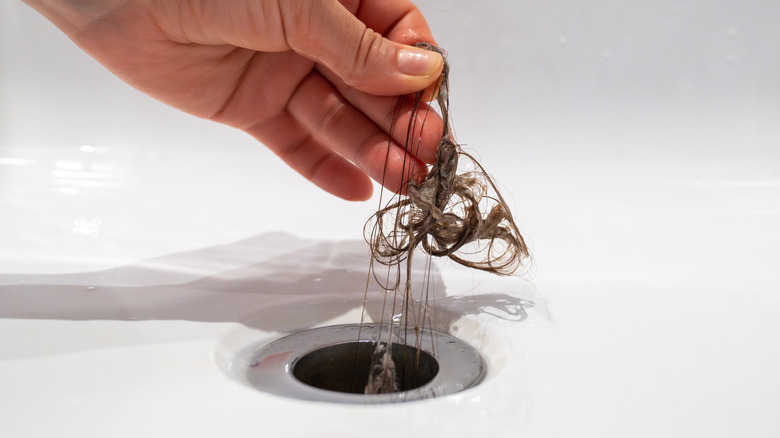 Close-up of hair being pulled out of a drain