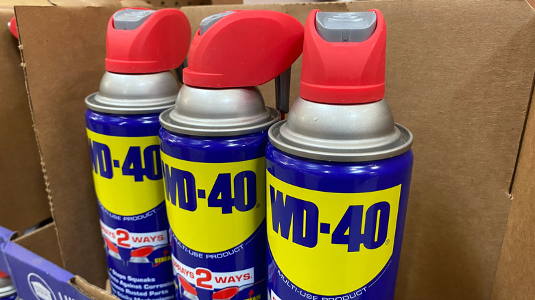 Three cans of WD-40 sit in an open box