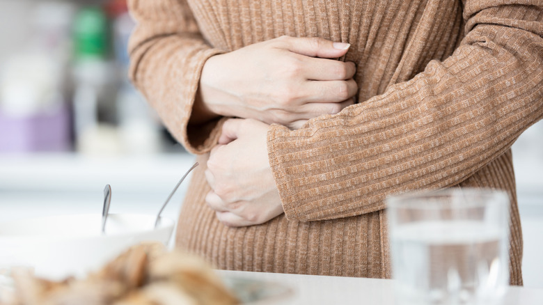 Person holding their stomach, feeling unwell