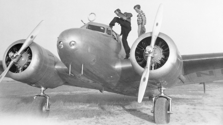 Amelia Earhart and Fred Noonan standing on Lockheed Electra