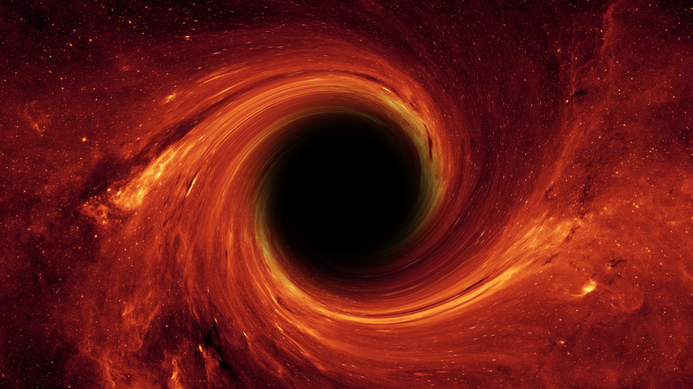 A black hole is surrounded by orange and red energy