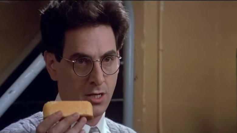 Harold Ramis playing Dr. Egon Spengler holding a Twinkie in 