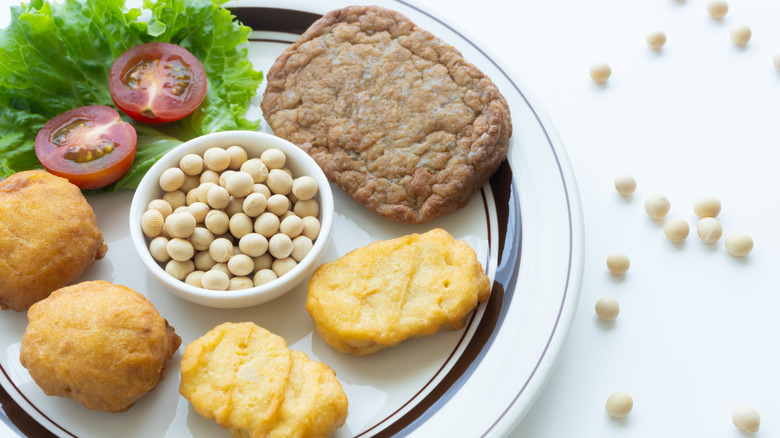 Plate of plant-based meat products with dry legumes in center of plate