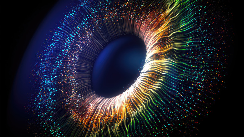 A series of particles intertwine to form an iris against a black background