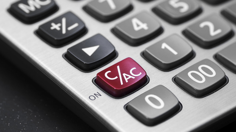 The buttons of a calculator are shown in closeup with the AC button in red