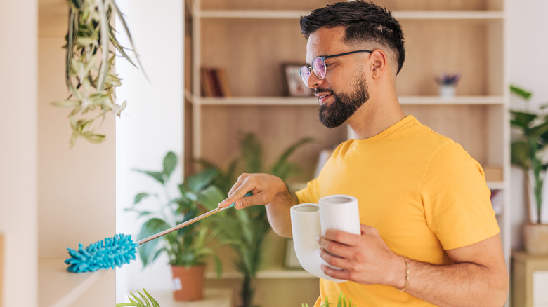 Man dusting around home