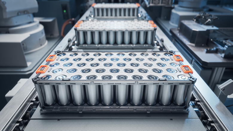 EV batteries roll down a conveyor belt in a factory