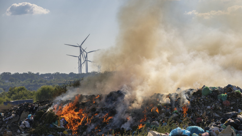 Garbage dump burning with solar panels in the background