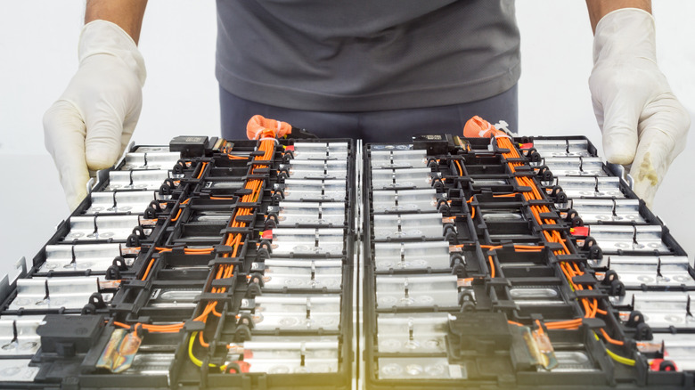 A technician dismantles an EV battery