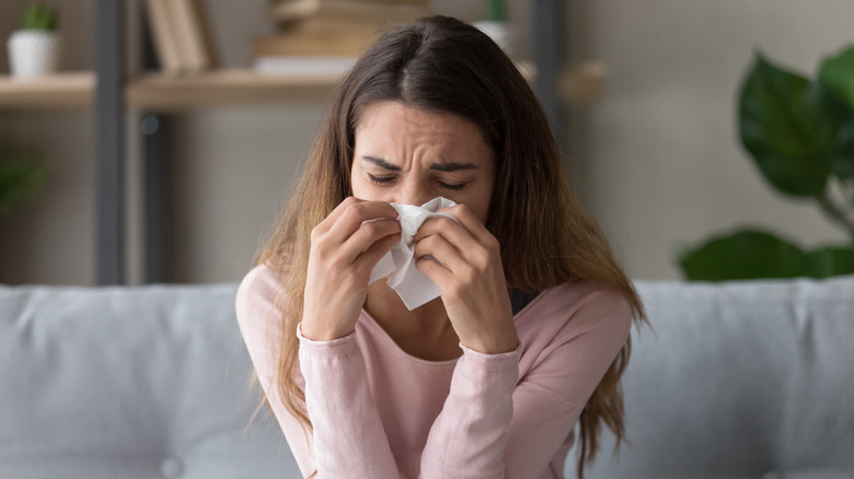Woman blowing her nose with a tissue