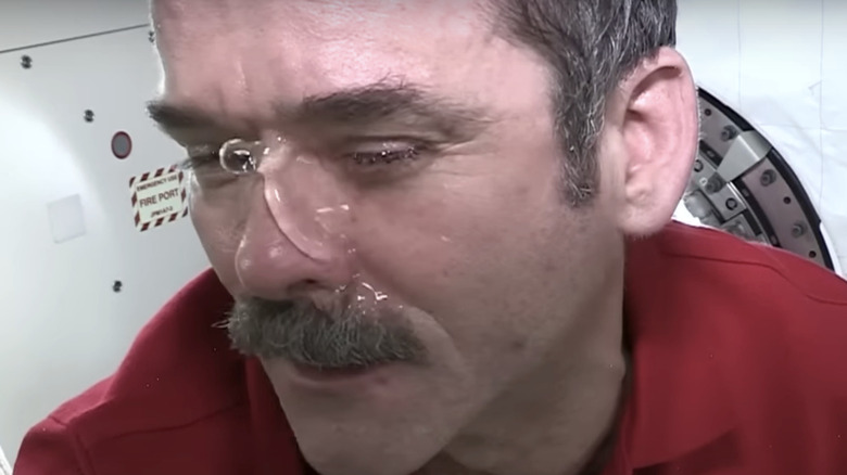 Chris Hadfield demonstrates water pooling on his face in a video taken aboard the International Space Station