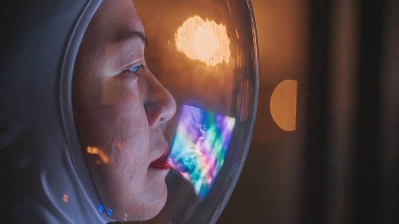 An astronaut looks out of her helmet in closeup