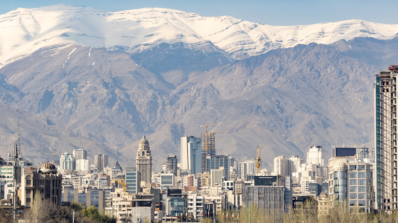 City of Tehran, tall buildings with snow-capped mountain range in background