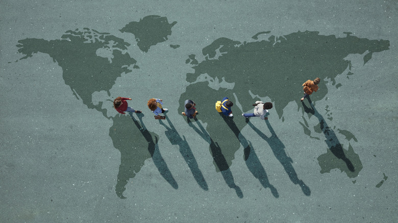group of people walking across a world map