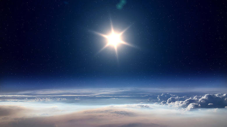 Earth, clouds at bottom, blue atmosphere in middle, sun and stars at top