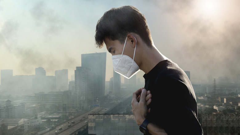 man wearing face mask in smoggy city