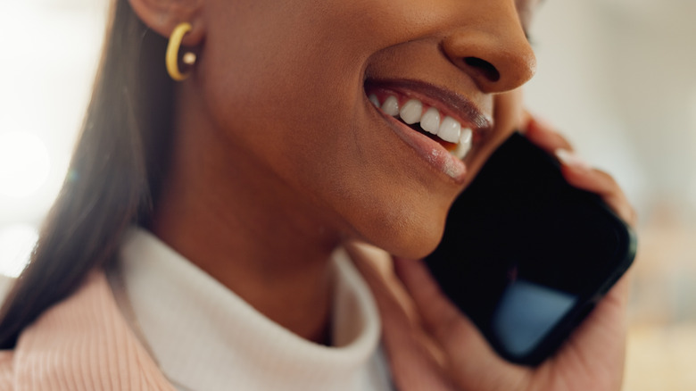 A closeup of a woman's mouth speaking on the phone