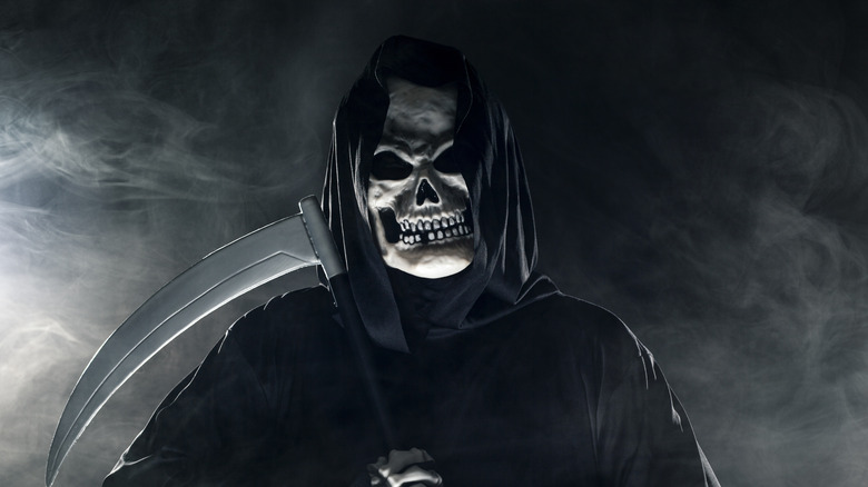 Scary grim reaper is looking through the mist