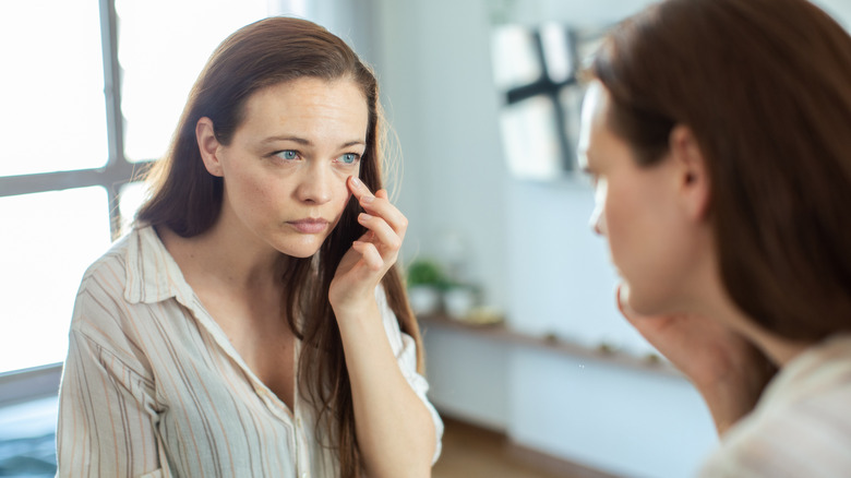 Woman looking at eyes in mirror