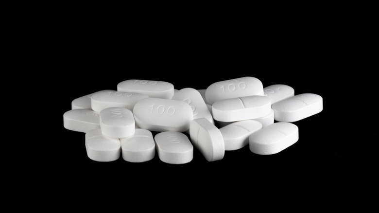 A pile of white pills on a black background.