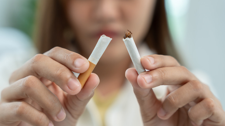 Woman breaking a cigarette with hands