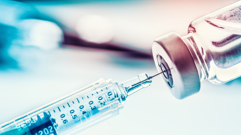 syringe removing liquid from a vial