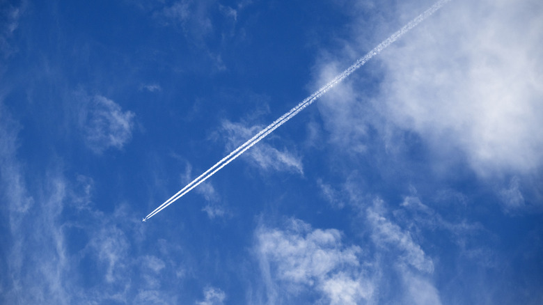Contrails behind a plane in the sky