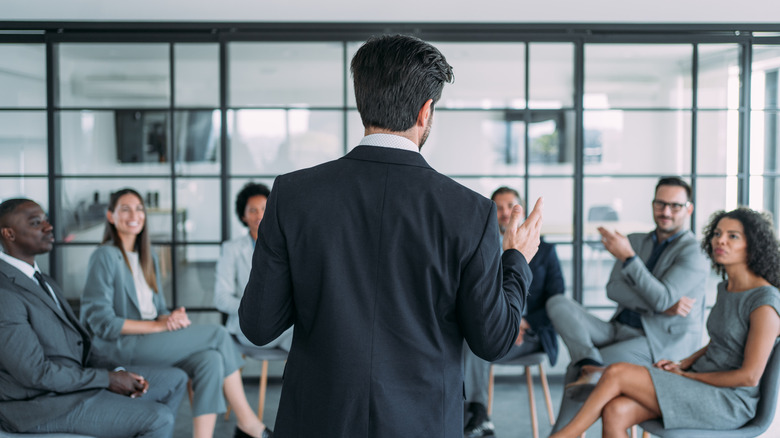 Man wearing a black suit while making presentation