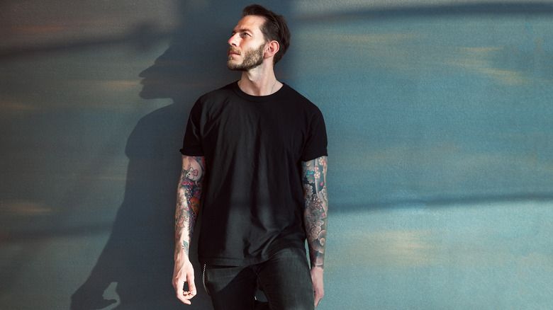 Man wearing all black against a wall