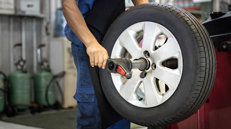 Mechanic using a tire balancing machine