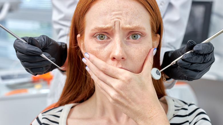 Woman with red hair with fear of dental treatment