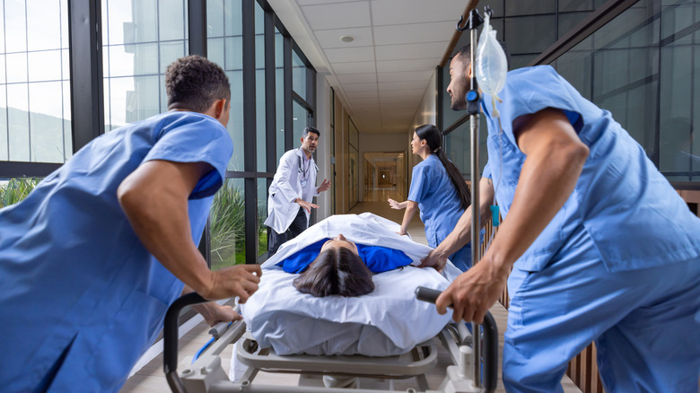 Emergency responders rushing woman on gurney into hospital
