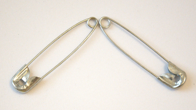 Two safety pins with the bottom holes facing each other