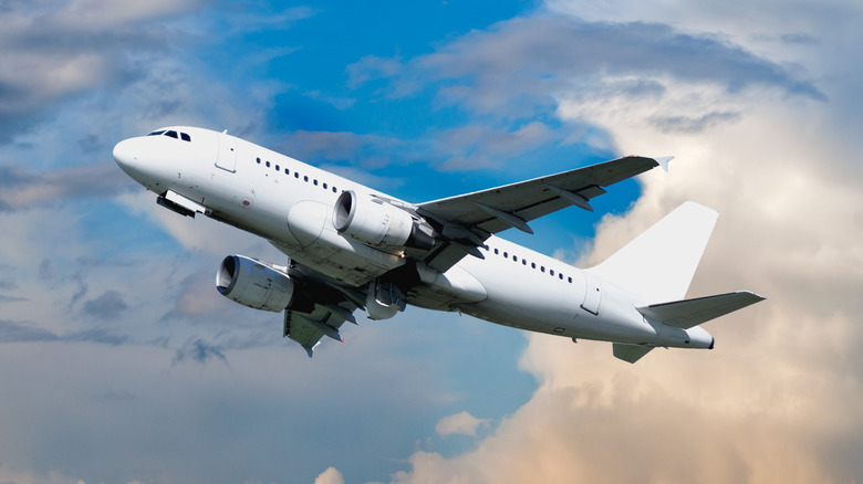 airplane flying against cloudy blue sky