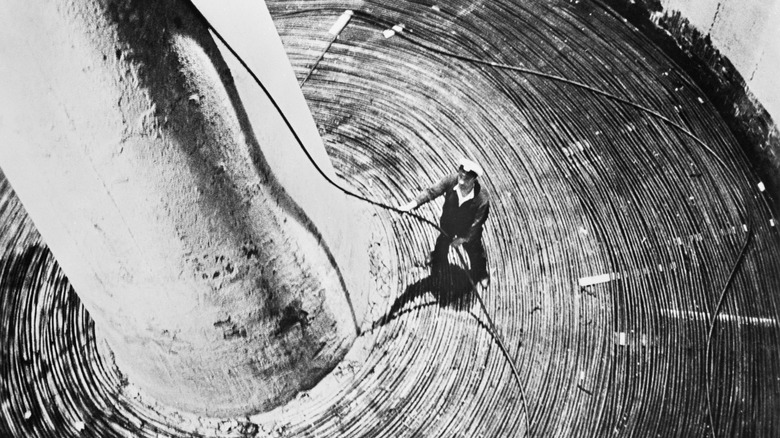 A sailor coils a fiber optic cable in a ship.