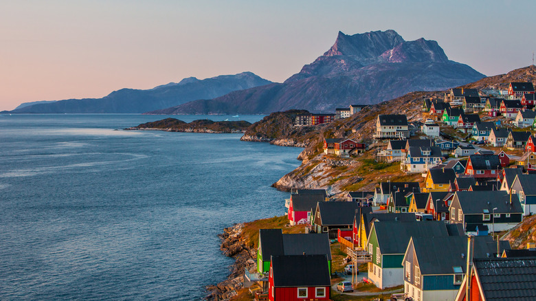 Colorful houses on the coast with mountains in the distance