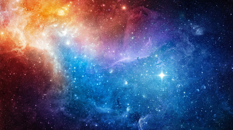 A shot of the cosmos shows stars, a nebula, and galaxies