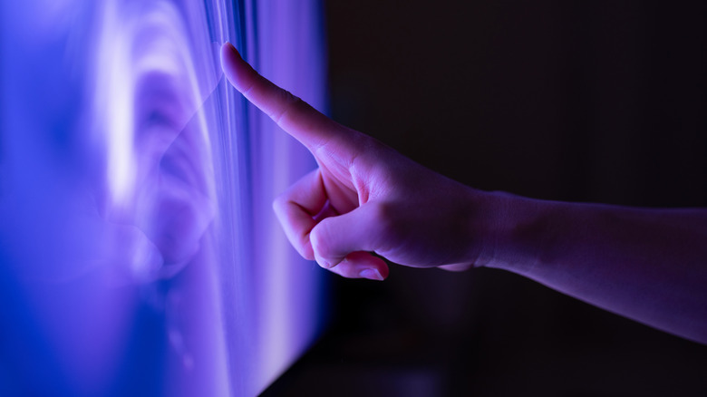hand touching television screen
