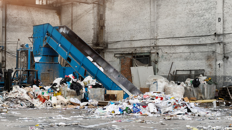 Plastic recycling plant, Large conveyor belt draws and separates piles of plastic waste