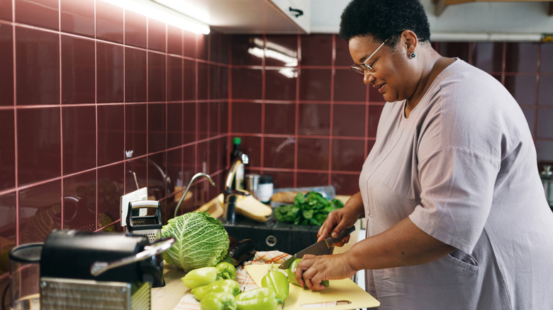 Woman cutting vegetables on a kitchen counter
