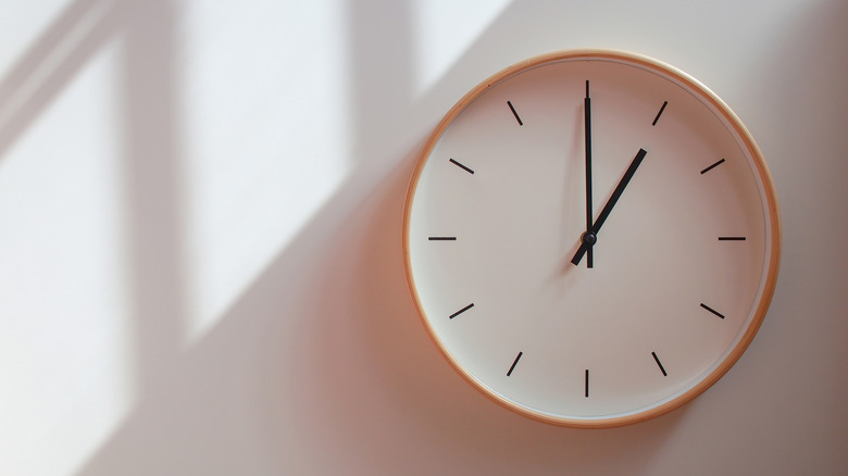 Wooden wall clock showing time of 1:00
