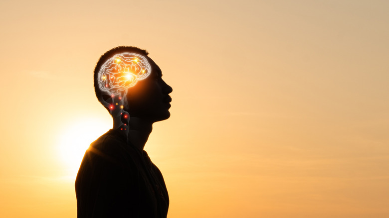 silhouette of a man with graphic x-ray image of his brain