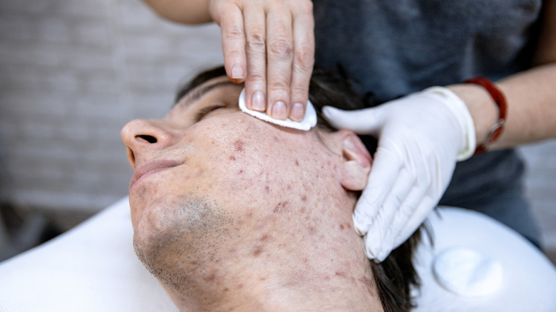 Man undergoing skin treatment from dermatologist